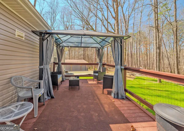 a view of a porch with furniture and a backyard
