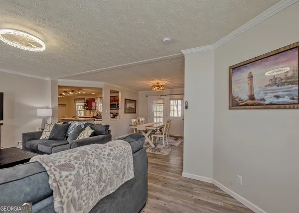 a living room with furniture a large window and wooden floor