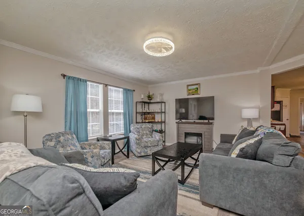 a bedroom with furniture a fireplace and a flat screen tv