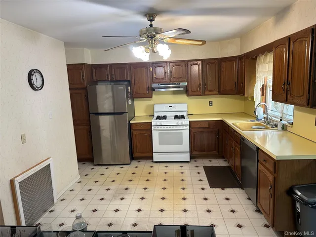 a kitchen with a sink a stove a refrigerator and cabinets