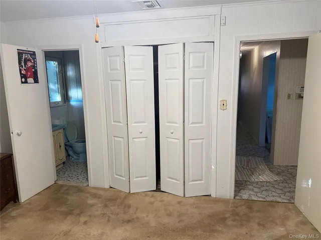 an empty room with closet and a bathroom
