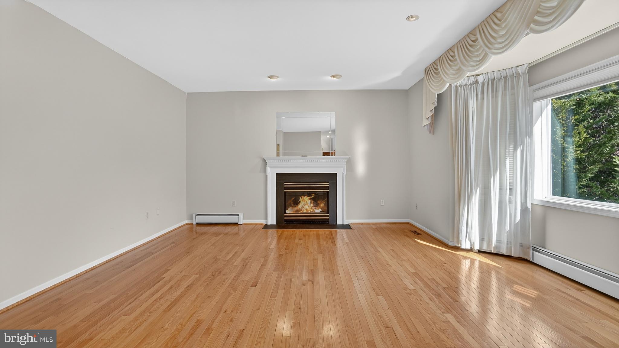 15022 Snowden Drive Silver Spring, MD 20905 - Photo 6 of 88 a view of an empty room with wooden floor fireplace and a window