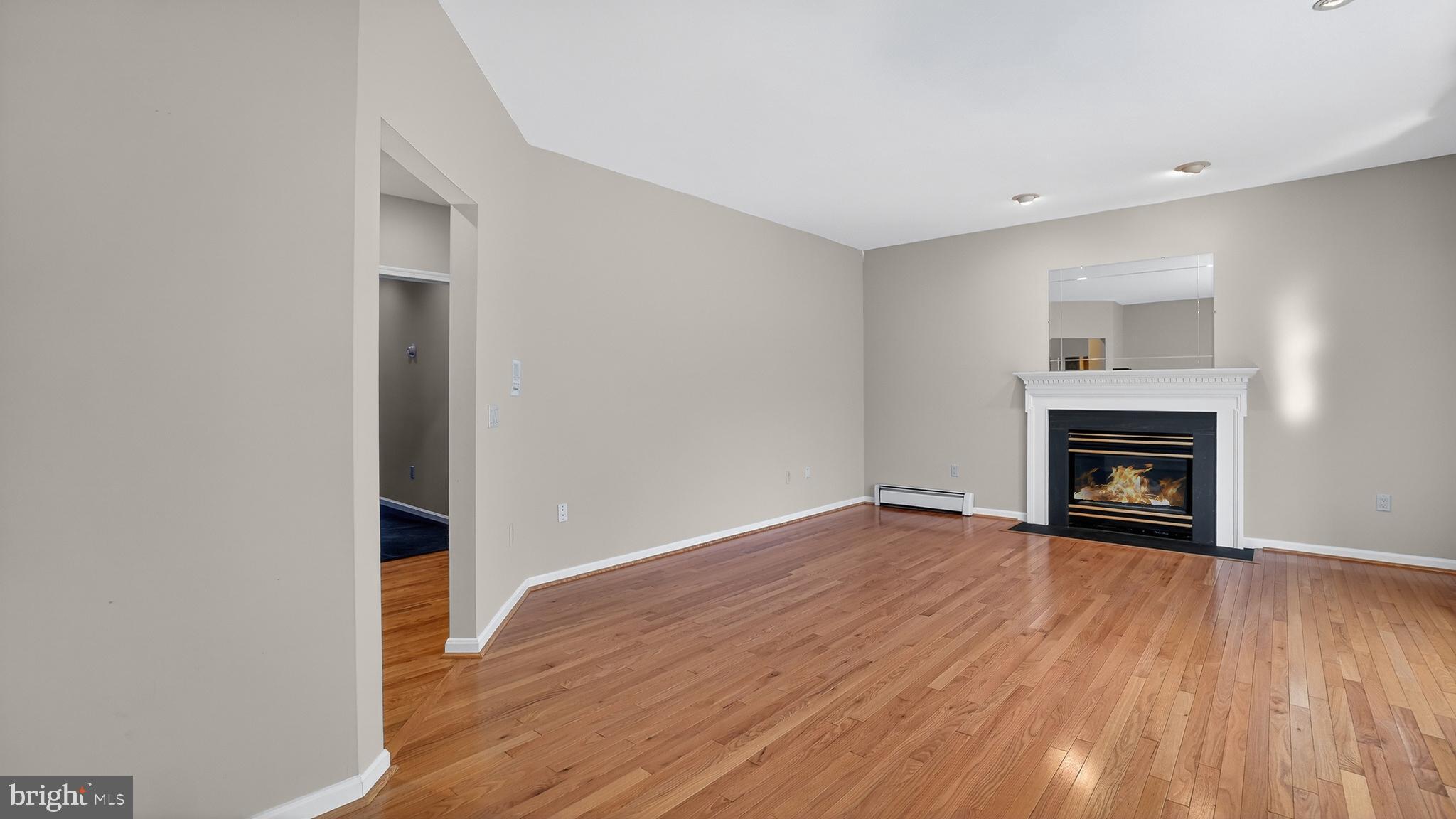15022 Snowden Drive Silver Spring, MD 20905 - Photo 9 of 88 a view of an empty room with wooden floor fireplace and a window