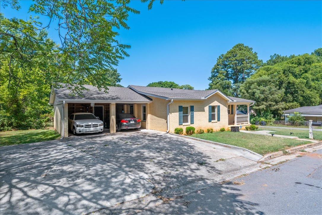 412 Sanders Street Anderson, SC 29624 - Photo 2 of 30 A well-maintained facade with a convenient attached carport provides practical parking solutions.