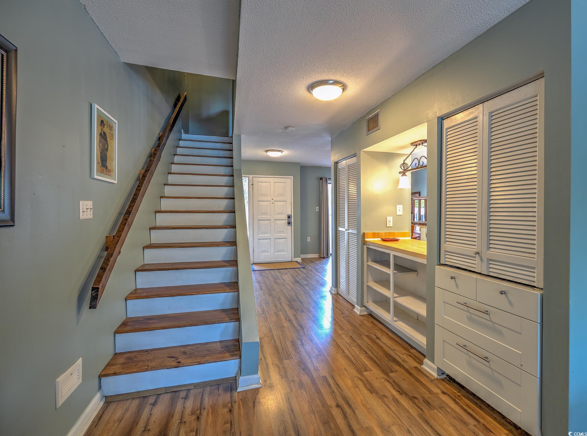 59 Mayrant Bluff Road, Unit 64 Georgetown, SC 29440 - Photo 14 of 36 Stairway featuring baseboards, a textured ceiling,