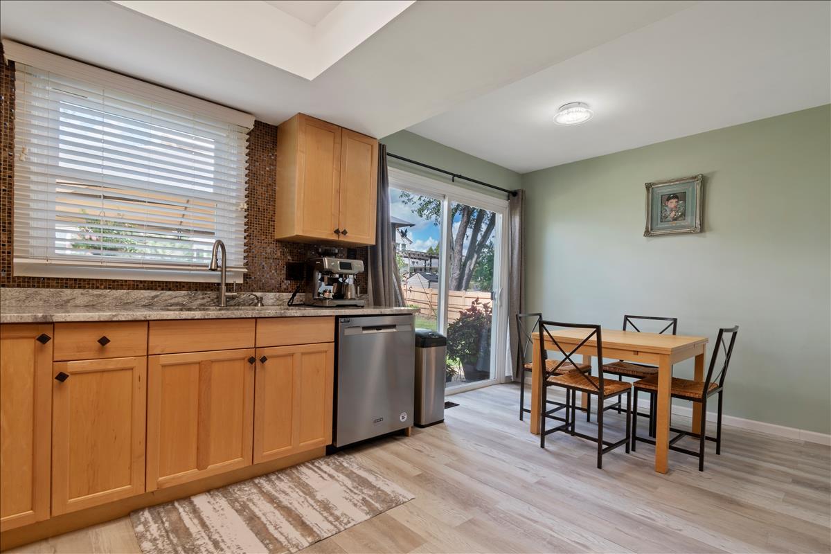 110 Stonegate Road Buffalo Grove, IL 60089 - Photo 9 of 25 a kitchen with stainless steel appliances granite countertop a sink a stove a dining table and chairs