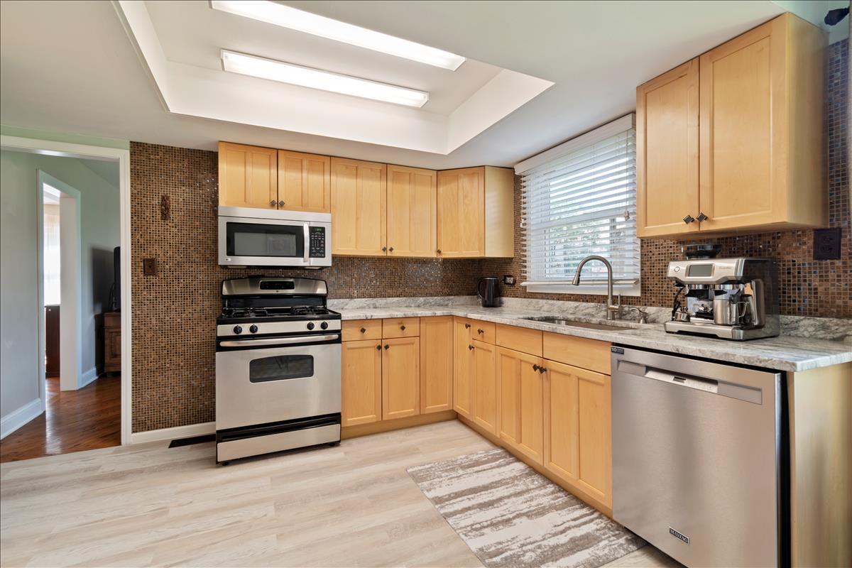 110 Stonegate Road Buffalo Grove, IL 60089 - Photo 10 of 25 a kitchen with granite countertop a stove a sink and a refrigerator