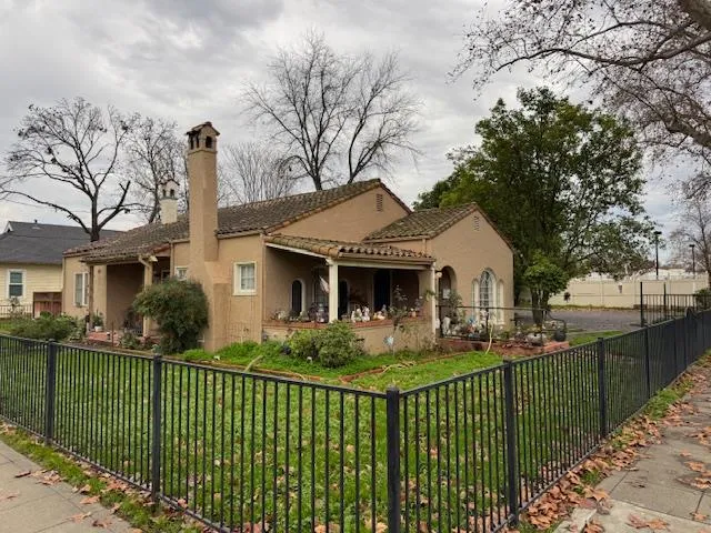 a front view of a house with a garden and plants