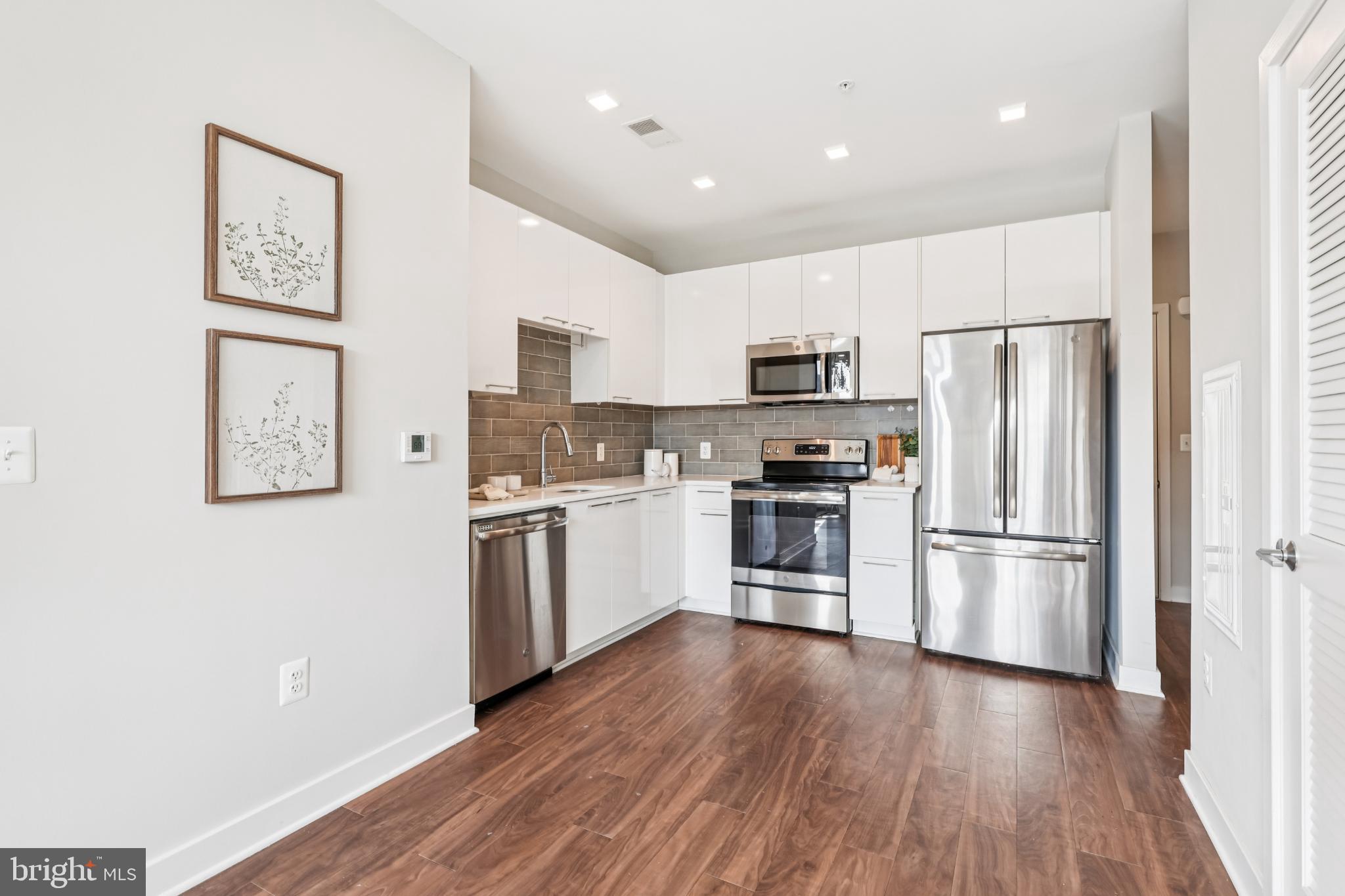 989 South Buchanan Street, Unit 225 Arlington, VA 22204 - Photo 14 of 42 a kitchen with a refrigerator cabinets and wooden floor