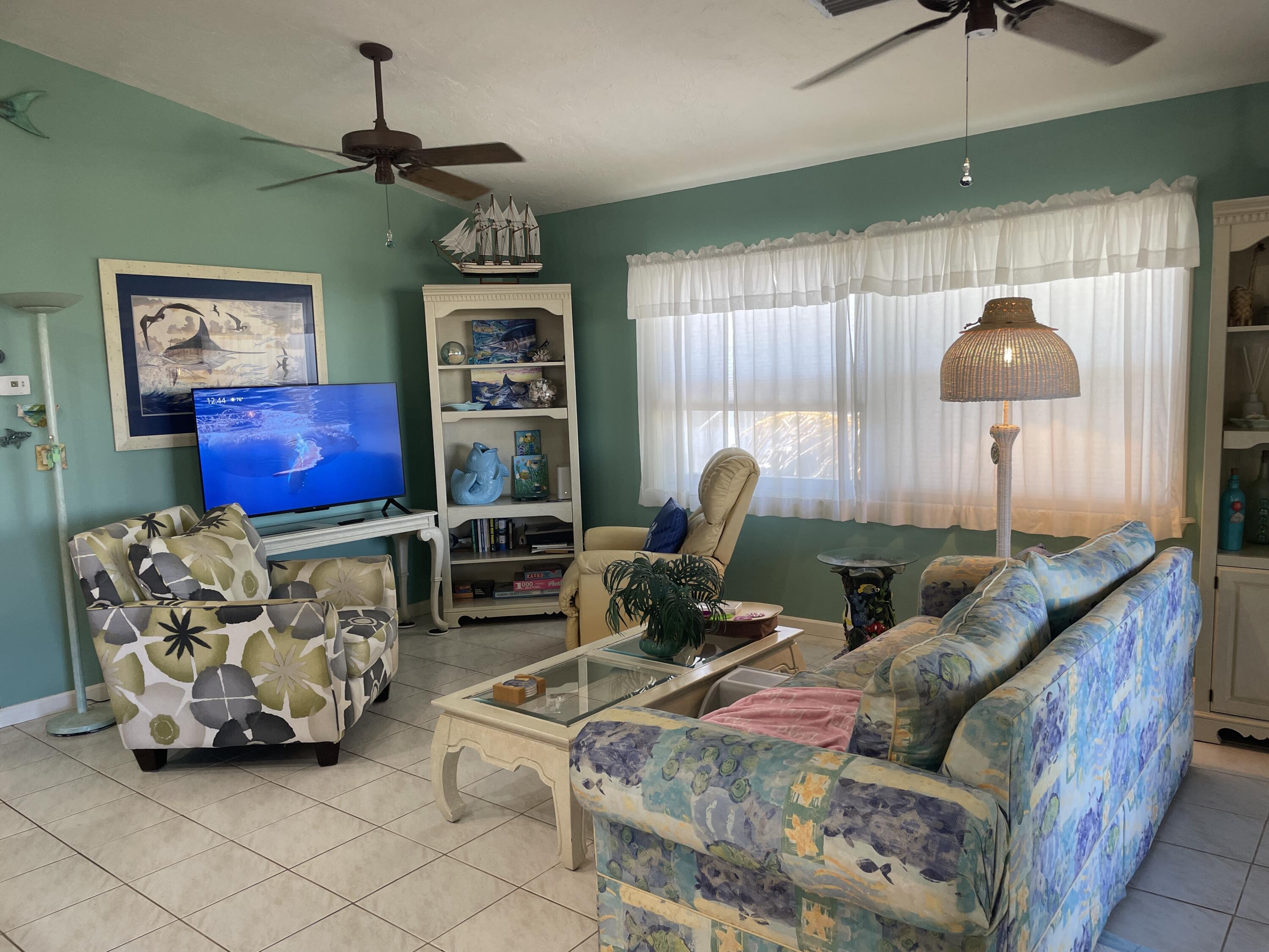 22979 Sharp Lane Cudjoe, FL 33042 - Photo 12 of 18 a living room with furniture a chandelier and a flat screen tv