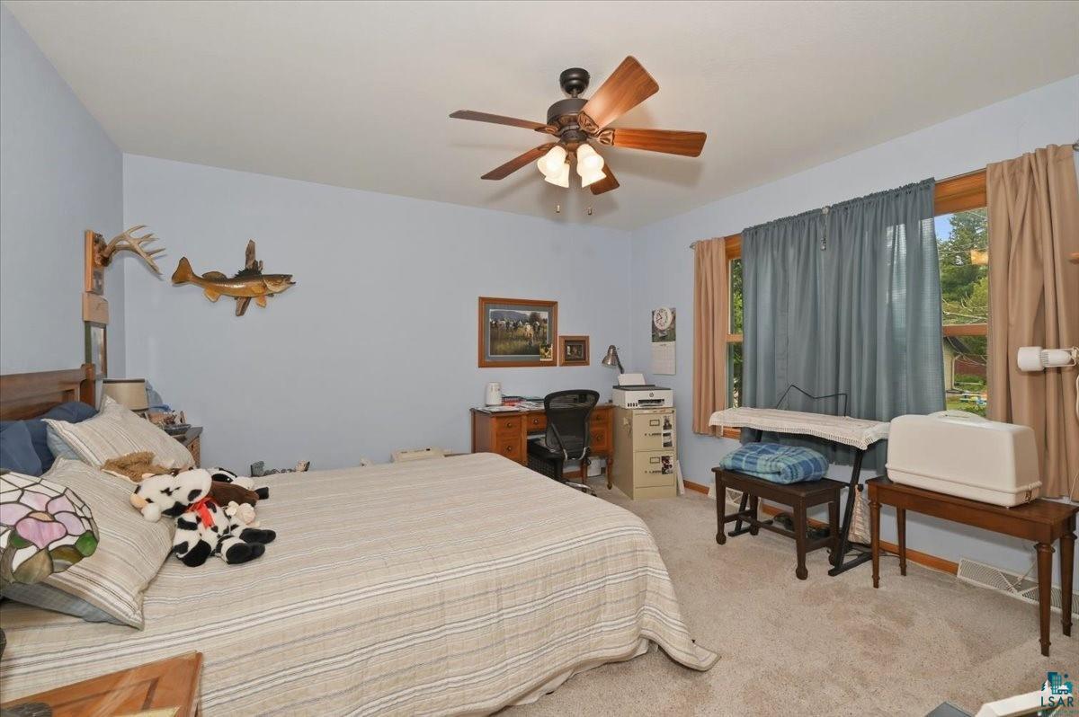 8162 South Dowling Road West Superior, WI 54880 - Photo 9 of 15 Carpeted room featuring a ceiling fan with light fixture, natural wood window trim, and baseboard molding