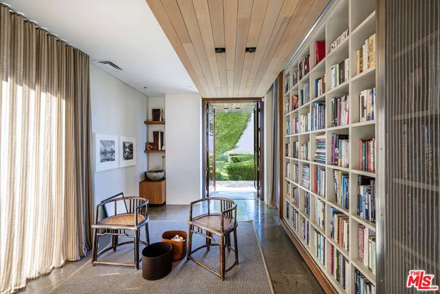 a living room with furniture a bookshelf and a wooden floor