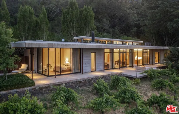 a front view of a house with garden and patio