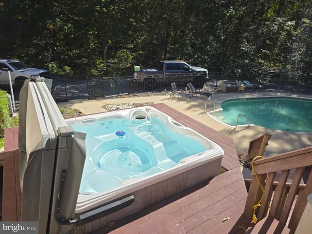 an empty room with wooden floor chandelier and windows