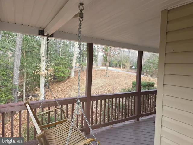 a view of a livingroom with wooden floor and kitchen
