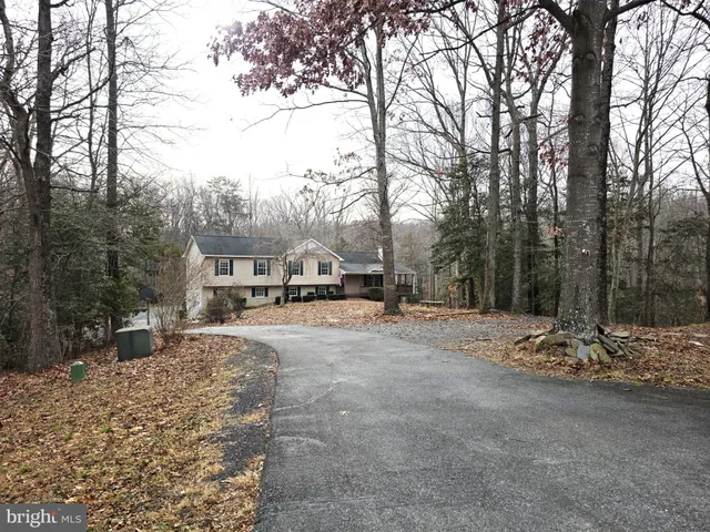 a backyard of a house with trees and outdoor seating