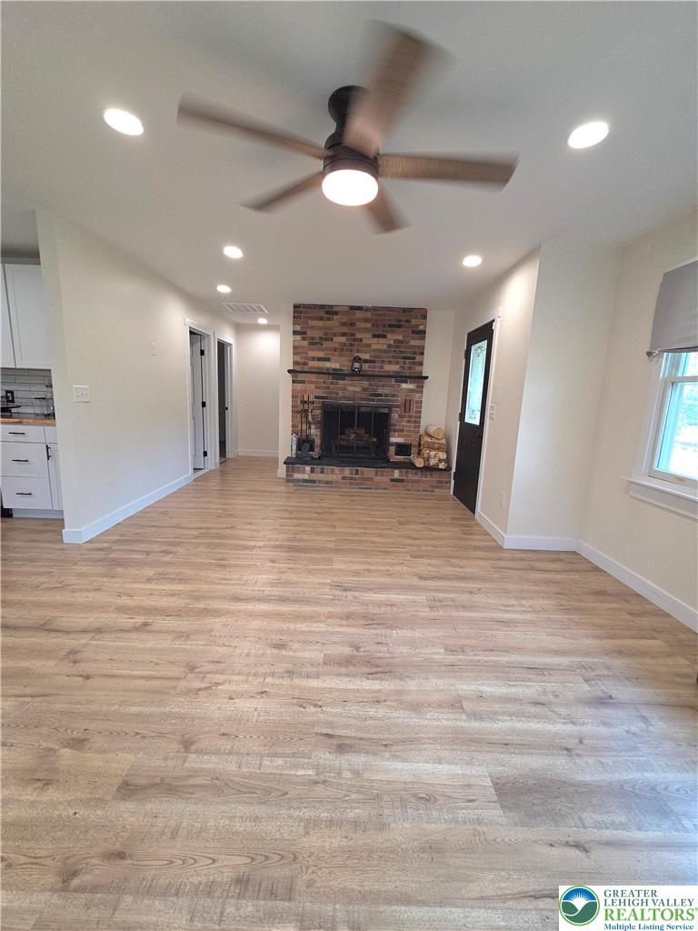 89 Short Ridge Road Albrightsville, PA 18210 - Photo 17 of 71 Gleaming wood floors lead to a classic floor-to-ceiling brick fireplace in this airy room.