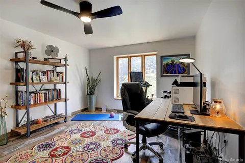 a view of a workspace with furniture and a book shelf