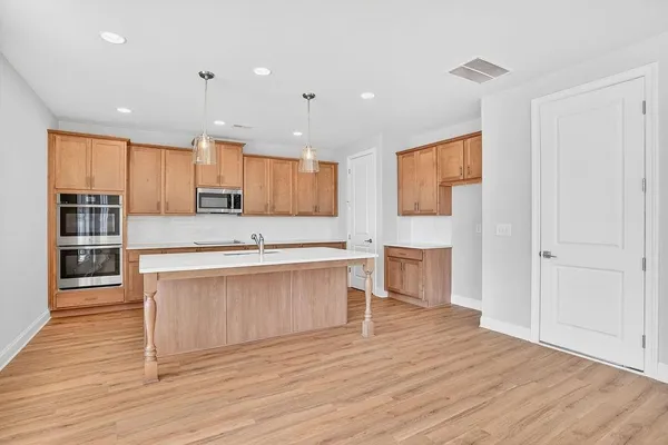 a large kitchen with stainless steel appliances granite countertop a stove a sink and a refrigerator