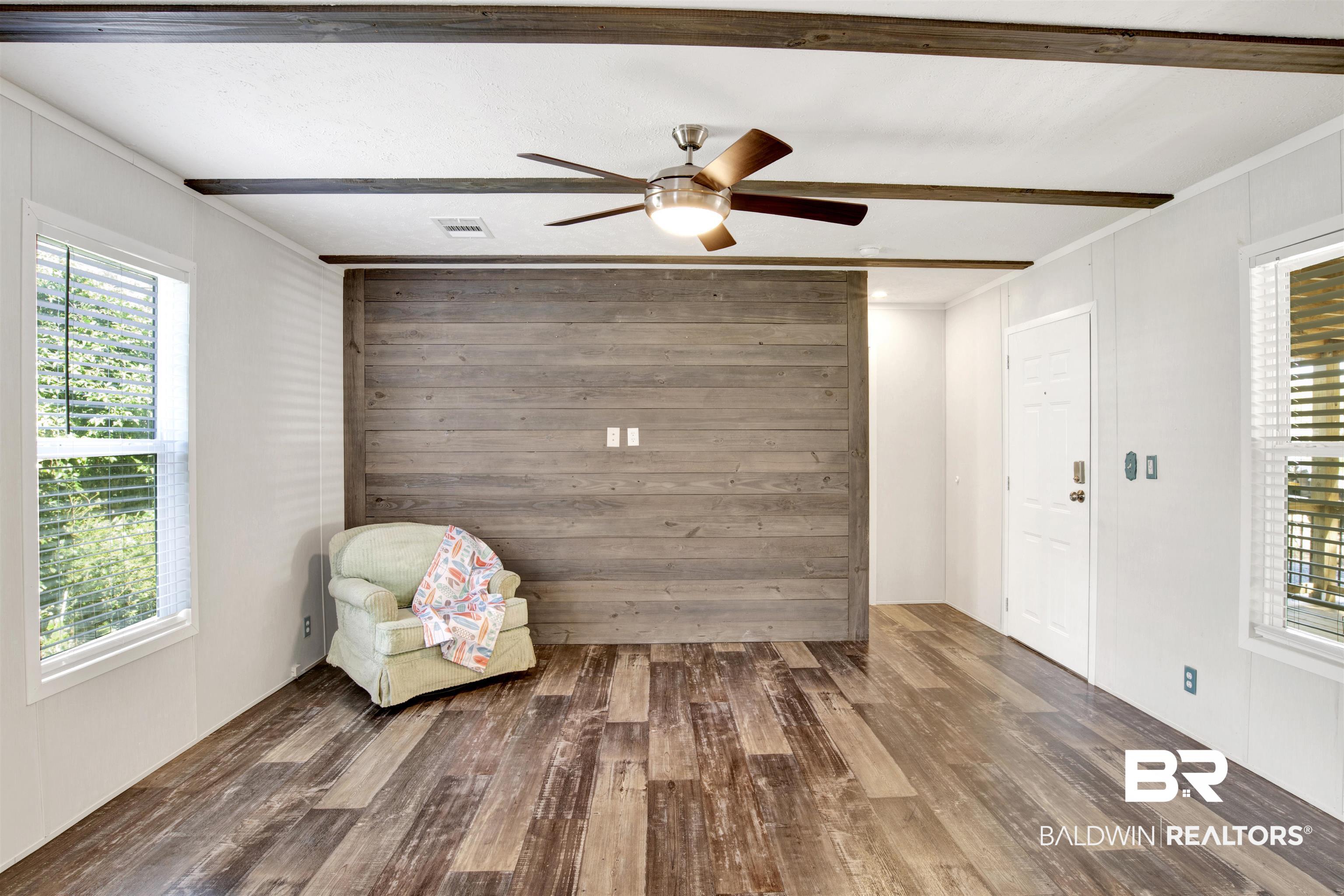 1411 Ridgewood Drive Lillian, AL 36549 - Photo 10 of 30 Unfurnished room with beam ceiling, ceiling fan, hardwood / wood-style floors, and crown molding