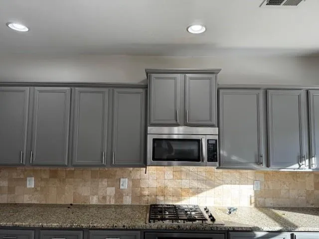 a kitchen with granite countertop a stove and a microwave with granite countertops