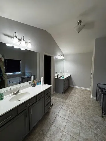 a view with a double vanity sink mirror and lamp