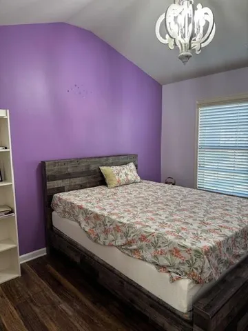 a bedroom with a bed and a chandelier