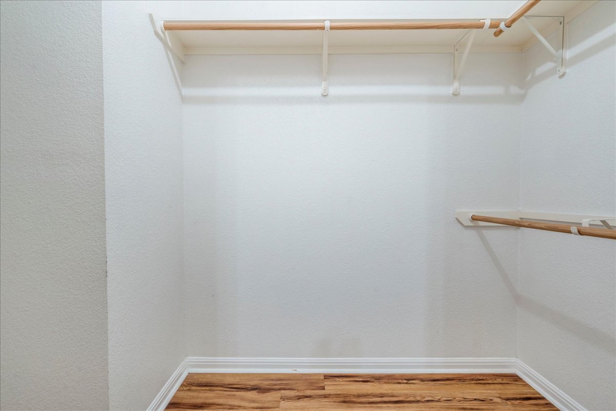6801 Porter Street Austin, TX 78741 - Photo 17 of 30 An empty walk-in closet with ample hanging space and attractive wood flooring.