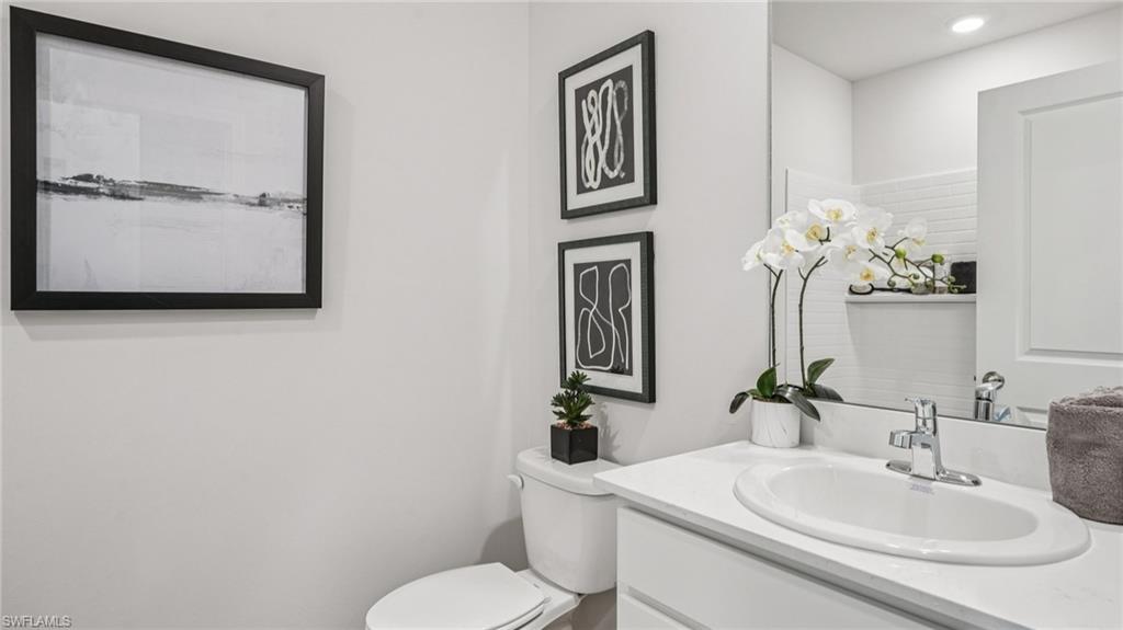 17625 Shade Tree Loop Babcock Ranch, FL 33982 - Photo 11 of 34 a bathroom with a toilet sink and mirror