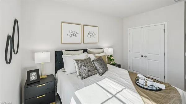 a bedroom with a bed and painting on the wall