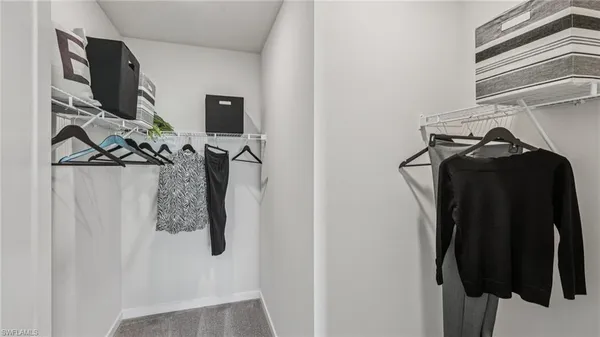 a view of walk in closet with clothes