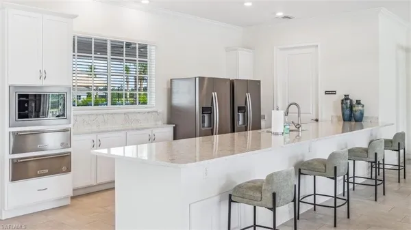 a large kitchen with kitchen island a large window and stainless steel appliances