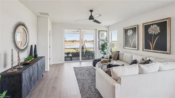 a living room with furniture a chandelier and a floor to ceiling window
