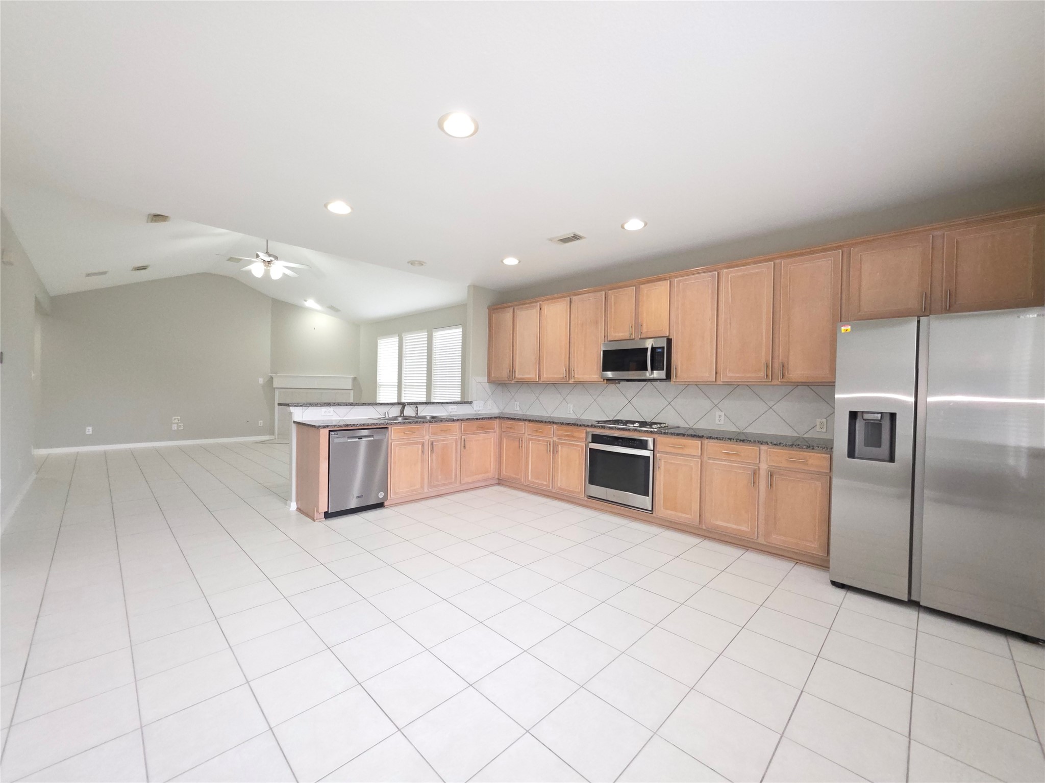 9603 Edgeloch Drive Spring, TX 77379 - Photo 2 of 16 a kitchen with stainless steel appliances kitchen island granite countertop a stove a sink and a refrigerator