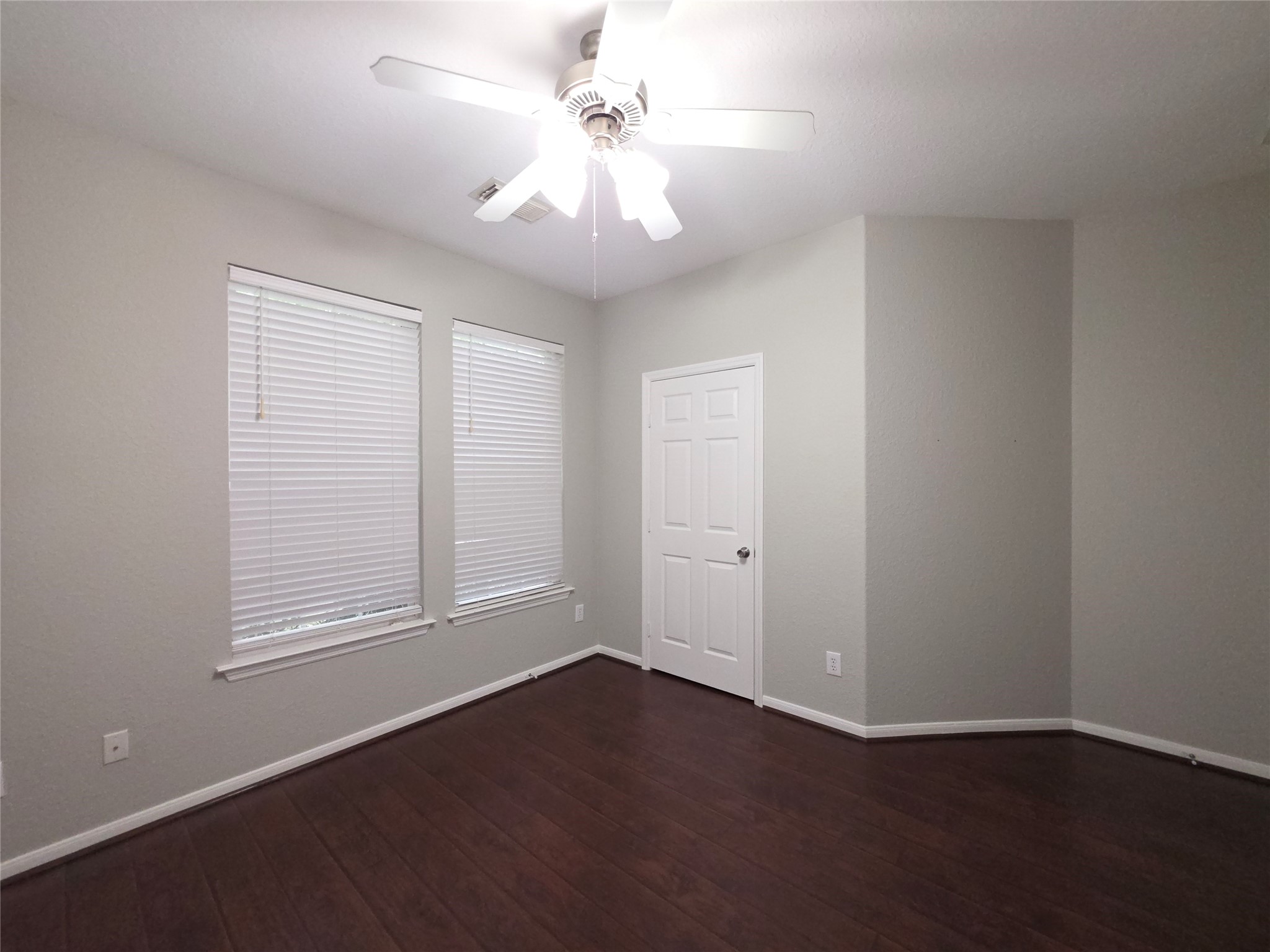 9603 Edgeloch Drive Spring, TX 77379 - Photo 10 of 16 an empty room with wooden floor chandelier fan and windows
