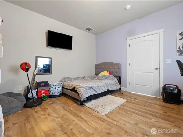 a bedroom with a bed a flat screen tv and a mirror