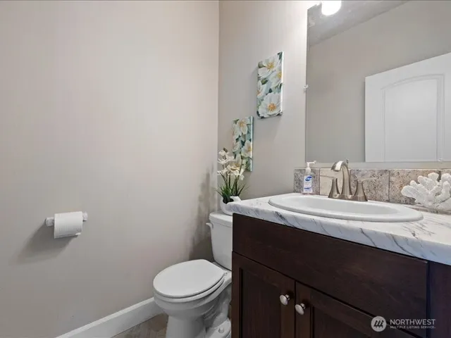 a bathroom with a granite countertop sink a toilet and mirror