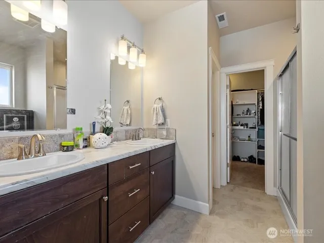 a en suite bathroom with a double vanity sink and a mirror