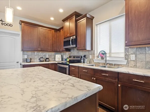 a kitchen with stainless steel appliances granite countertop a sink refrigerator and cabinets