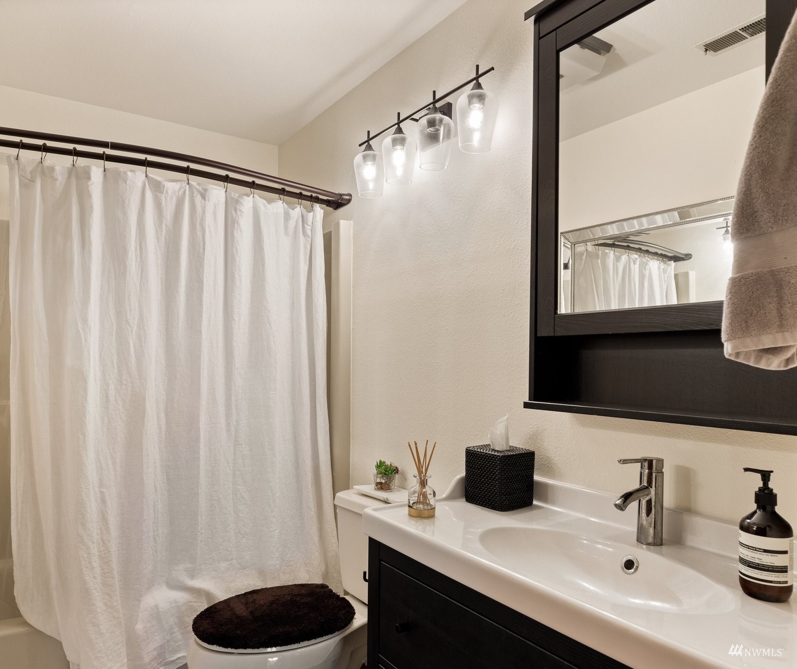 495 East Crescent Harbor Road Oak Harbor, WA 98277 - Photo 31 of 40 a bathroom with a sink a toilet and a mirror