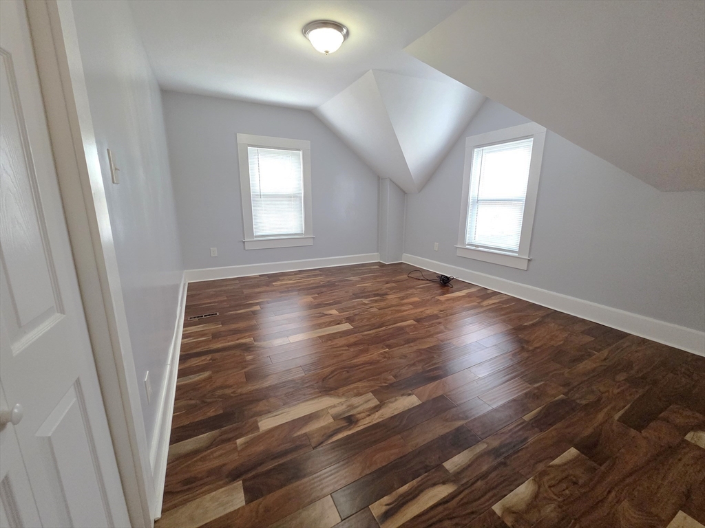 69 Pratt Street, Unit 1 Avon, MA 02322 - Photo 12 of 18 an empty room with wooden floor and windows