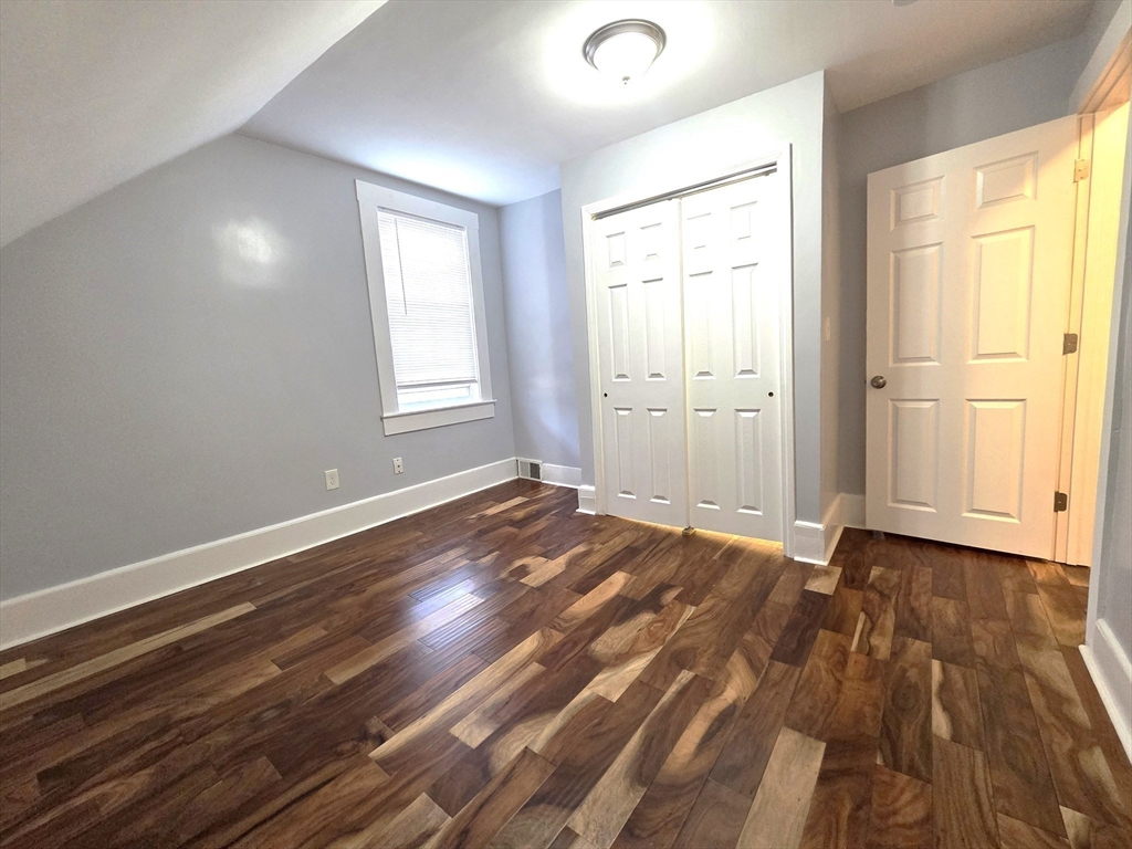 69 Pratt Street, Unit 1 Avon, MA 02322 - Photo 14 of 18 an empty room with wooden floor and windows