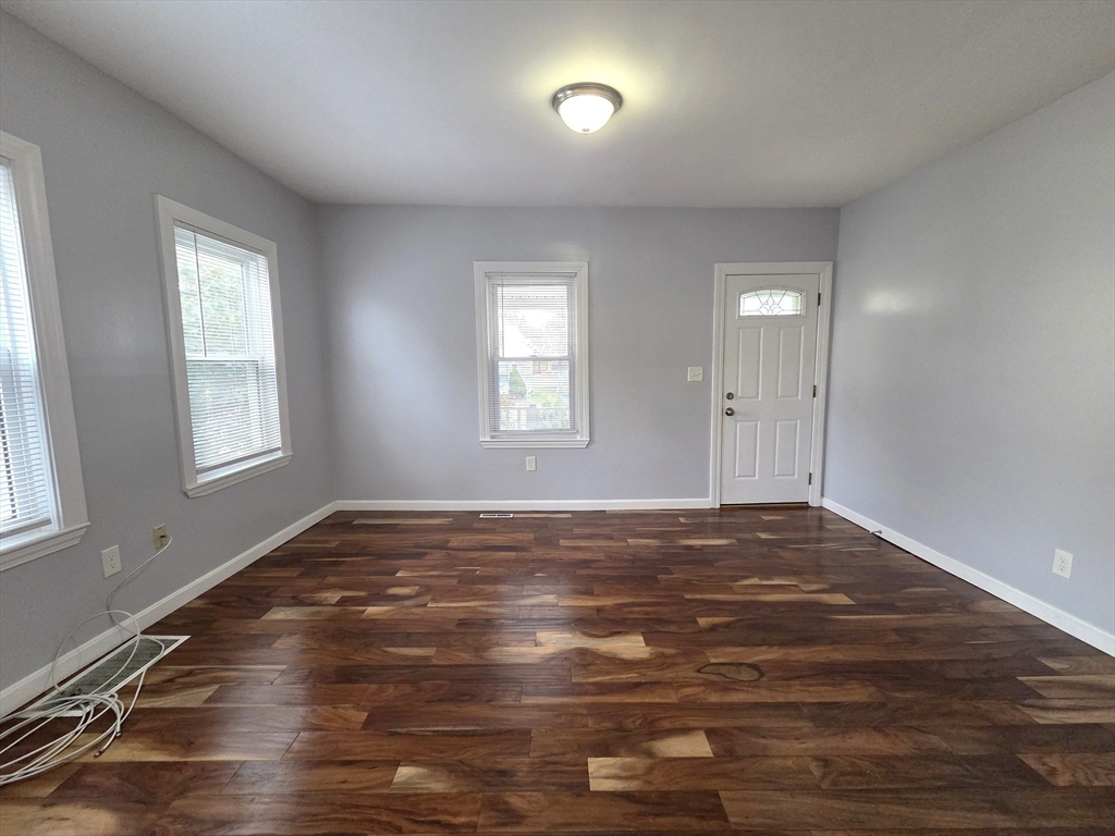 69 Pratt Street, Unit 1 Avon, MA 02322 - Photo 3 of 18 a view of an empty room with wooden floor and a window