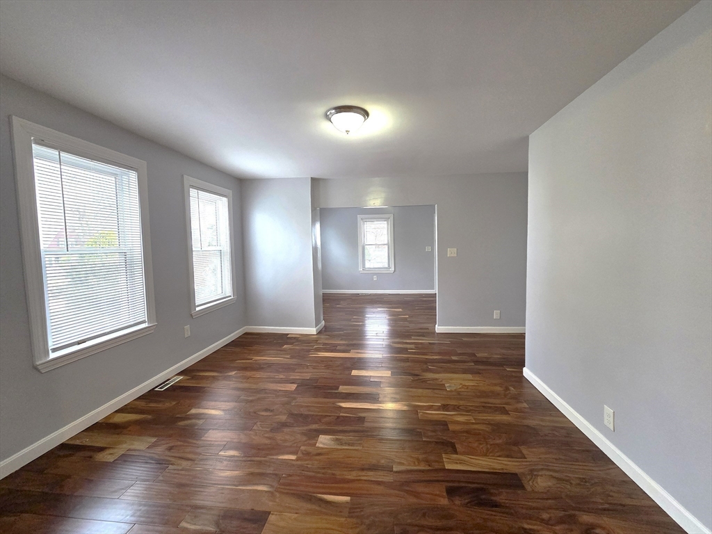 69 Pratt Street, Unit 1 Avon, MA 02322 - Photo 5 of 18 a view of empty room with window and wooden floor