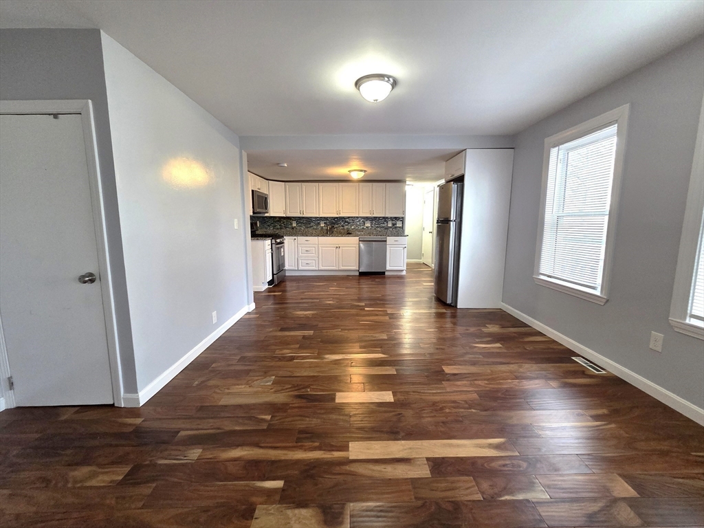 69 Pratt Street, Unit 1 Avon, MA 02322 - Photo 6 of 18 an empty room with wooden floor and windows