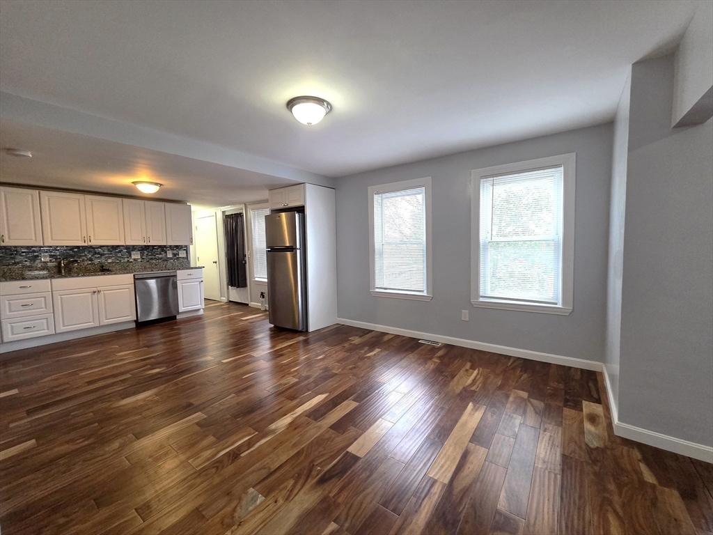 69 Pratt Street, Unit 1 Avon, MA 02322 - Photo 7 of 18 an empty room with wooden floor and windows
