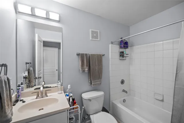 a bathroom with a bathtub shower sink mirror and toilet