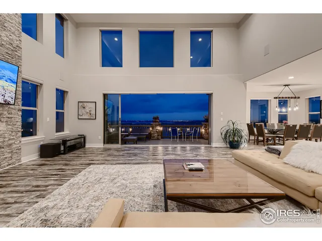 a living room with stainless steel appliances kitchen island granite countertop a table chairs and a view of living room