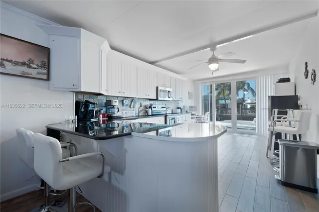 a kitchen with stainless steel appliances kitchen island granite countertop a sink and cabinets