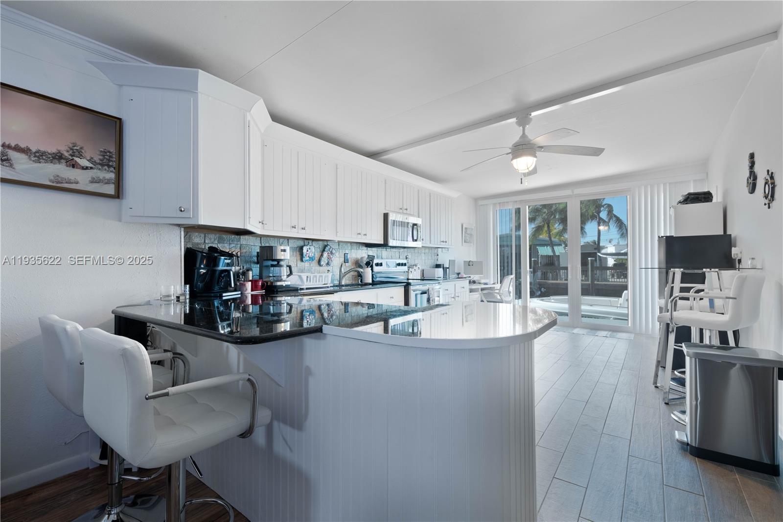 1361 Overseas Highway, Unit E11 Marathon, FL 33050 - Photo 13 of 29 a kitchen with stainless steel appliances kitchen island granite countertop a sink and cabinets